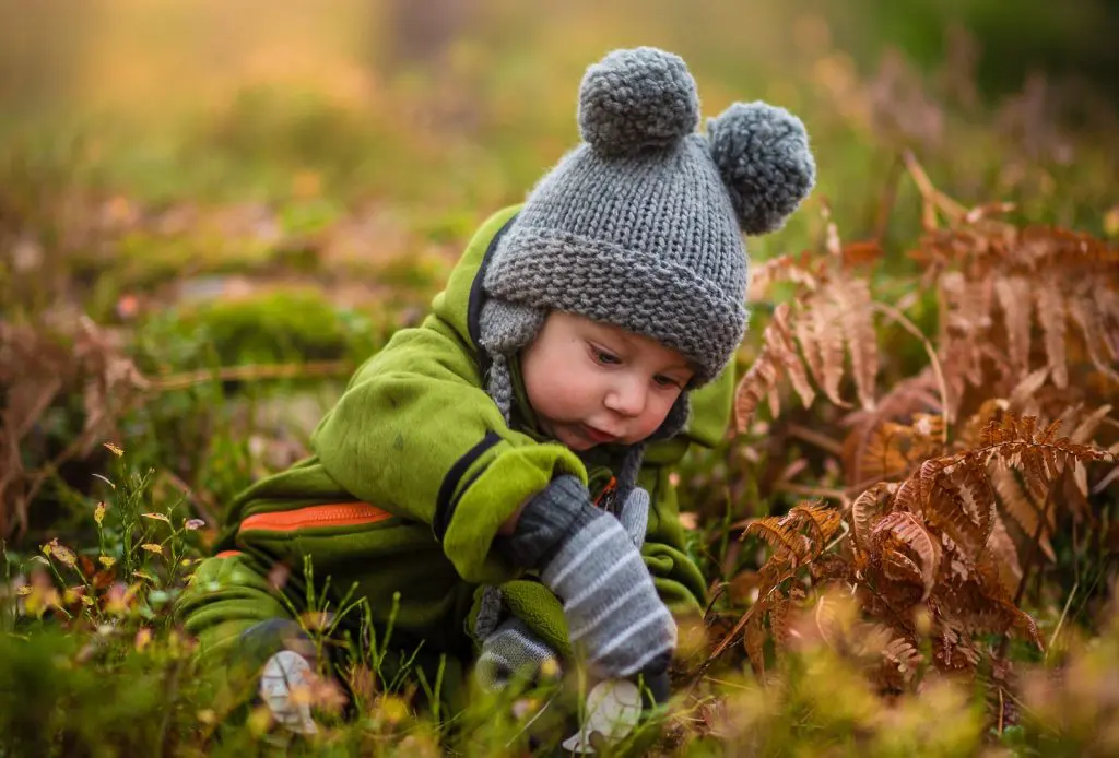 Baby child in knitwear playing outside