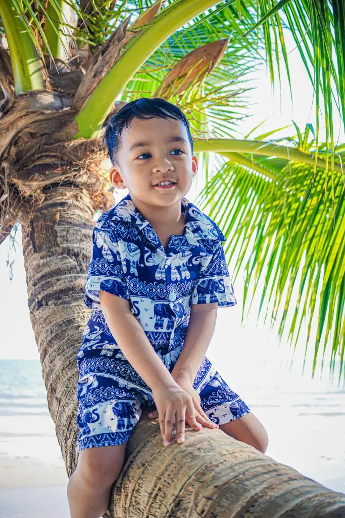 200 Place Inspired Boy Names That Are Unique and Exotic 5 Boy Sitting on a Palm Tree