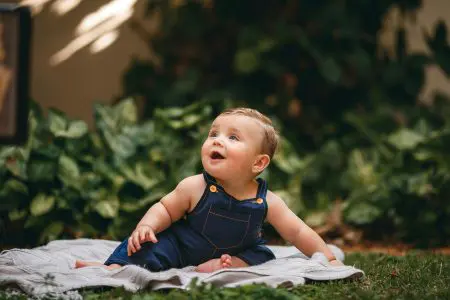 150 Sophisticated French Boy Names With Meanings 1 Baby in Jean Overalls Sitting on Blanket - Featured