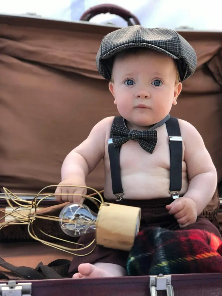 Boy in Hat Sitting in Suitcase