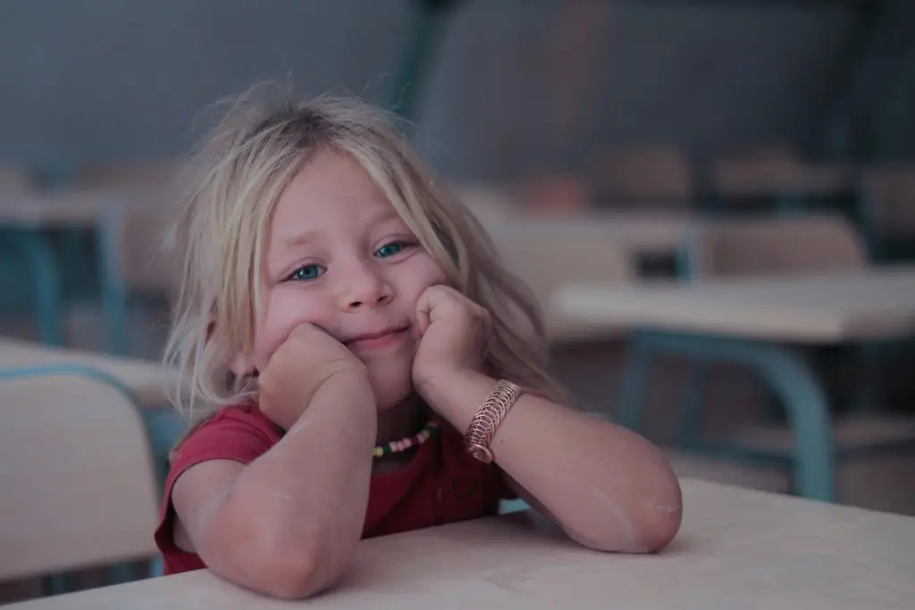 100+ Unique Girl Names That Start With G 5 Girl in Red Shirt Leaning on a Table