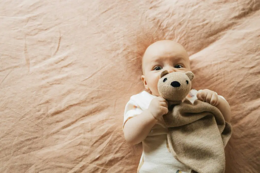 Baby with Teddy Bear on Bed
