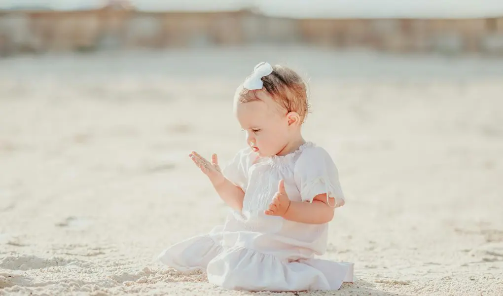 200 Unique Girl Names That Start With S 1 Adorable girl playing with sand on coast - Featured