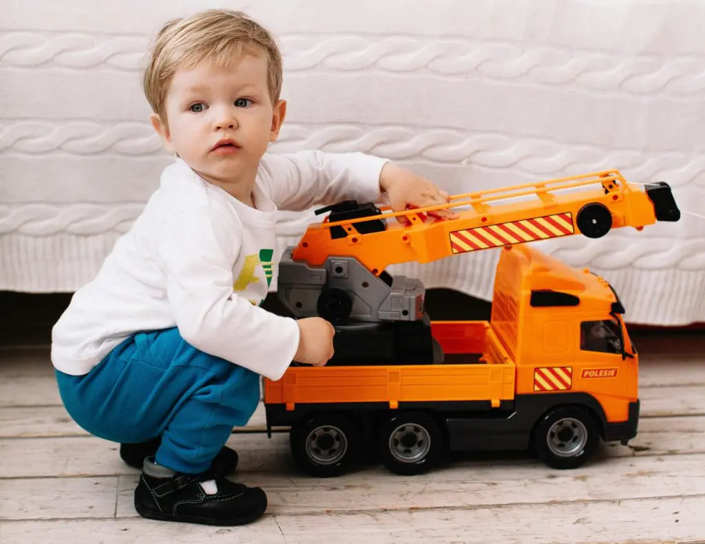 A Young Boy Playing Holding a Toy Truck