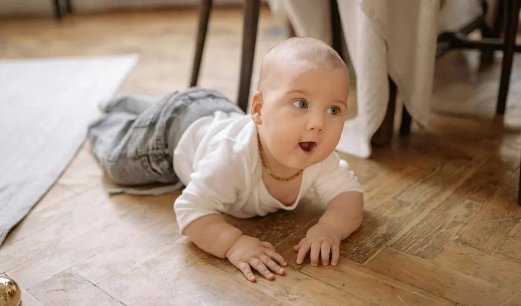 250+ Short and Sweet Three Letter Boy Names 13 A Baby Crawling On Wooden Floor