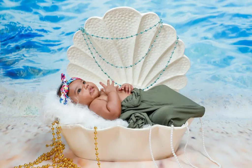 Four Syllable Girl Names (Graceful, Bold, and Unique) 11 Baby Lying on White Shell