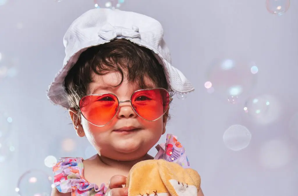 100 Romantic Boy Names That Will Steal Your Heart 14 Adorable Baby with Sunglasses and Plush Toy Surrounded by Bubbles