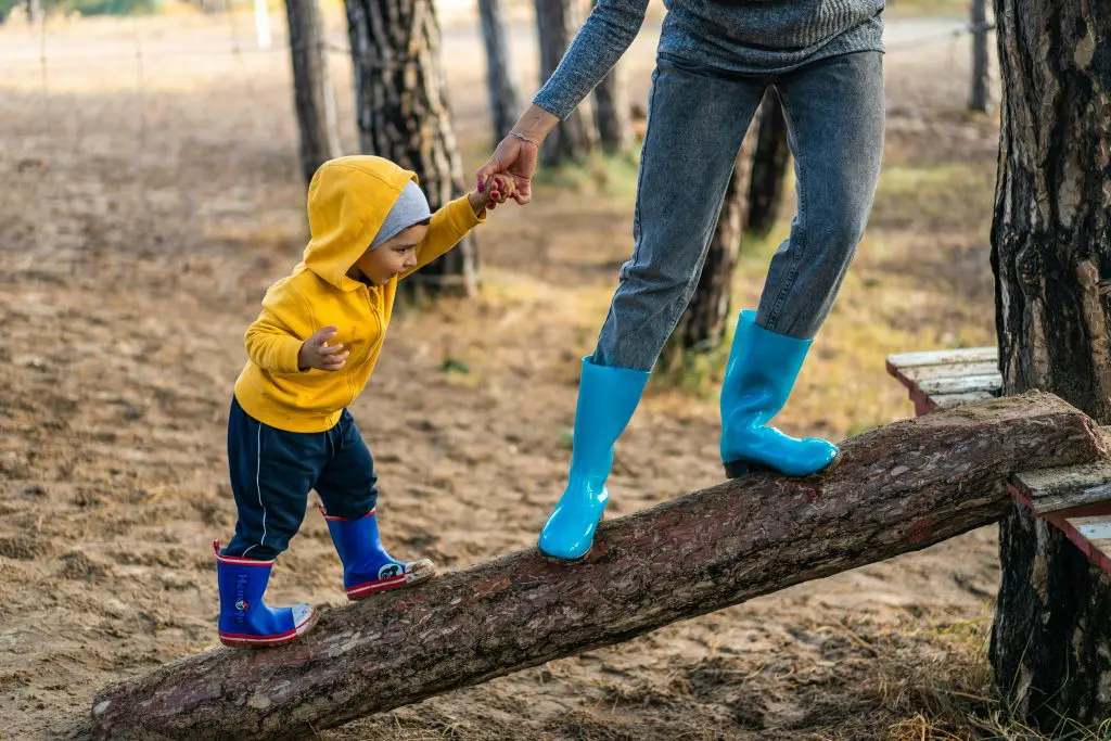 Toddler walking on fallen tree