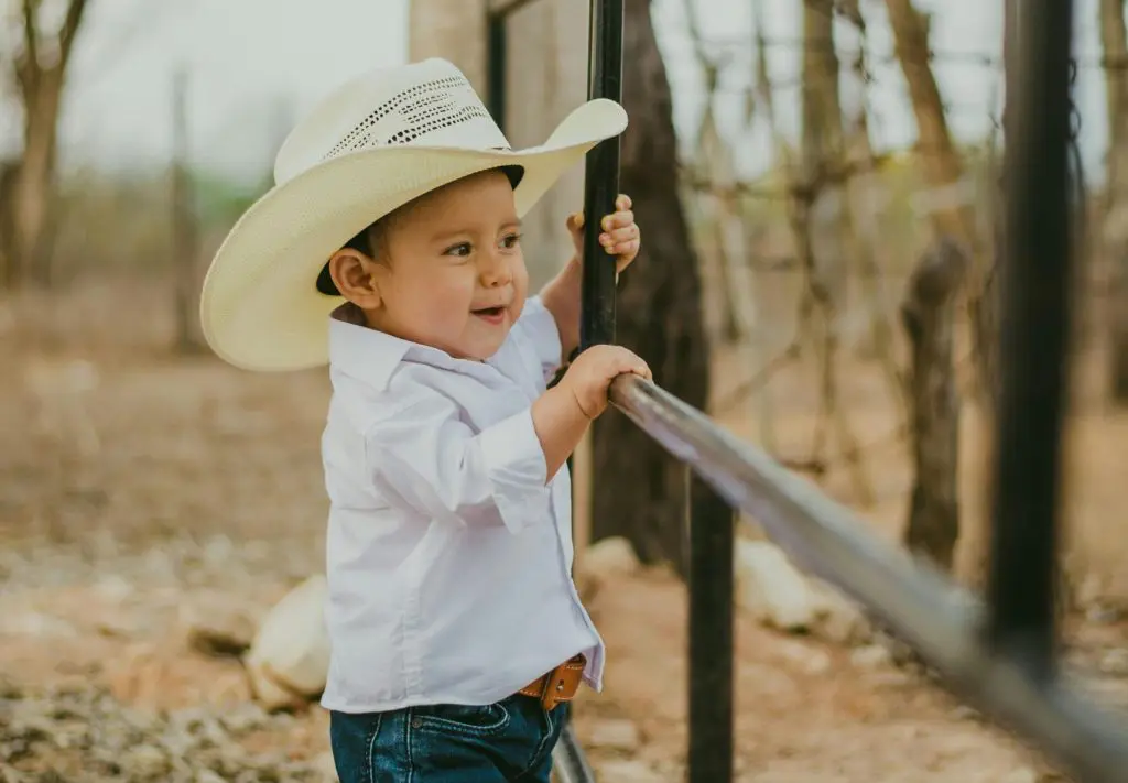 350 Handsome Southern Boy Names 6 Boy in Shirt and Hat near Bars
