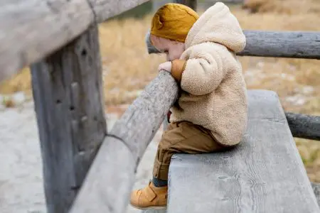 Baby Leaning On Wooden Fence - Featured