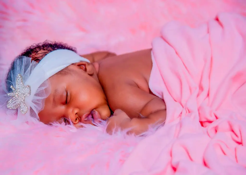 Baby Lying on Pink Textile