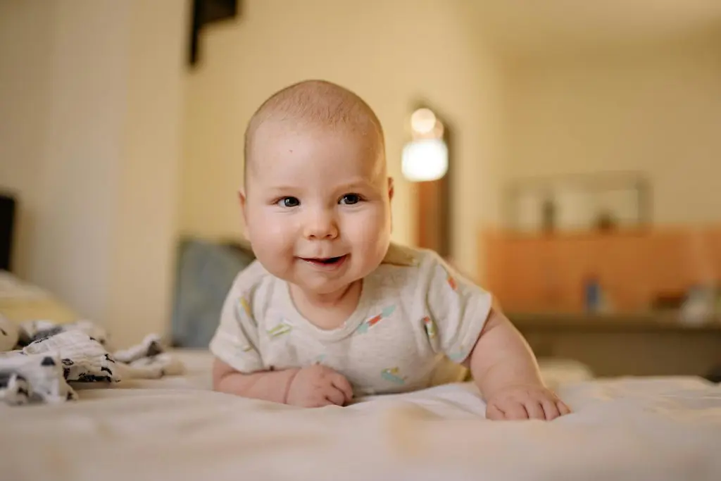 100 Romantic Boy Names That Will Steal Your Heart 3 Baby in Gray Onesie Lying on Bed