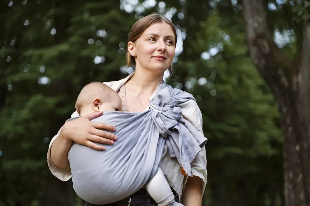 Woman holding baby in nursing cloth
