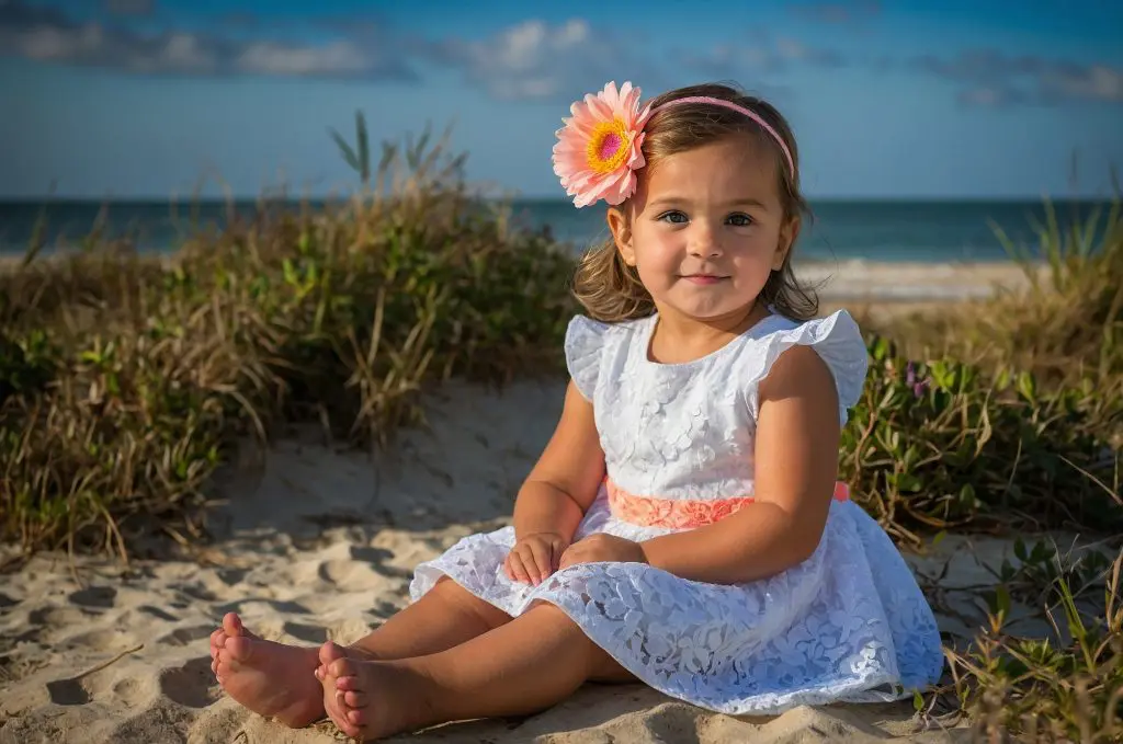 125 Beachy Girl Names With Meanings 14 Little Girl Sitting on a beach