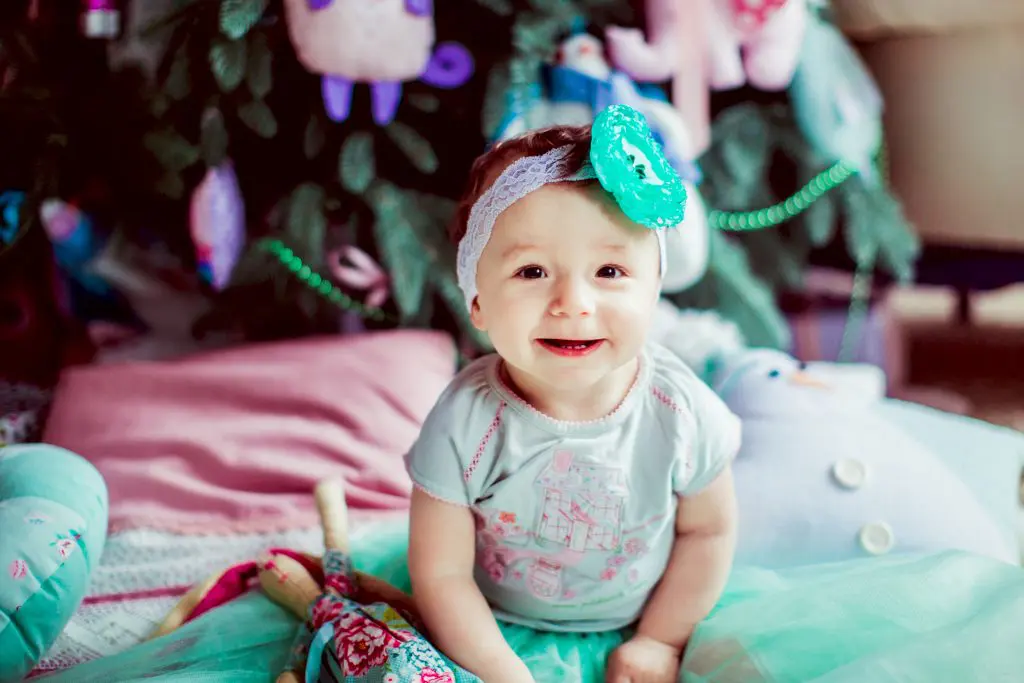 Pretty little child with mint flower on her head sitting