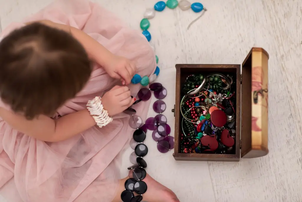 80 Gemstone Girl Names For Your Little Jewel 11 Beautiful cute little girl in pink dress enjoying while playing with mother's jewel