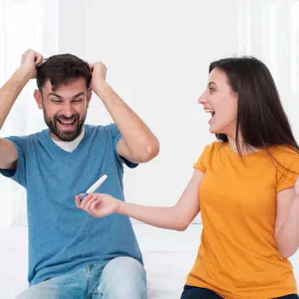 Excited couple holding pregnancy test