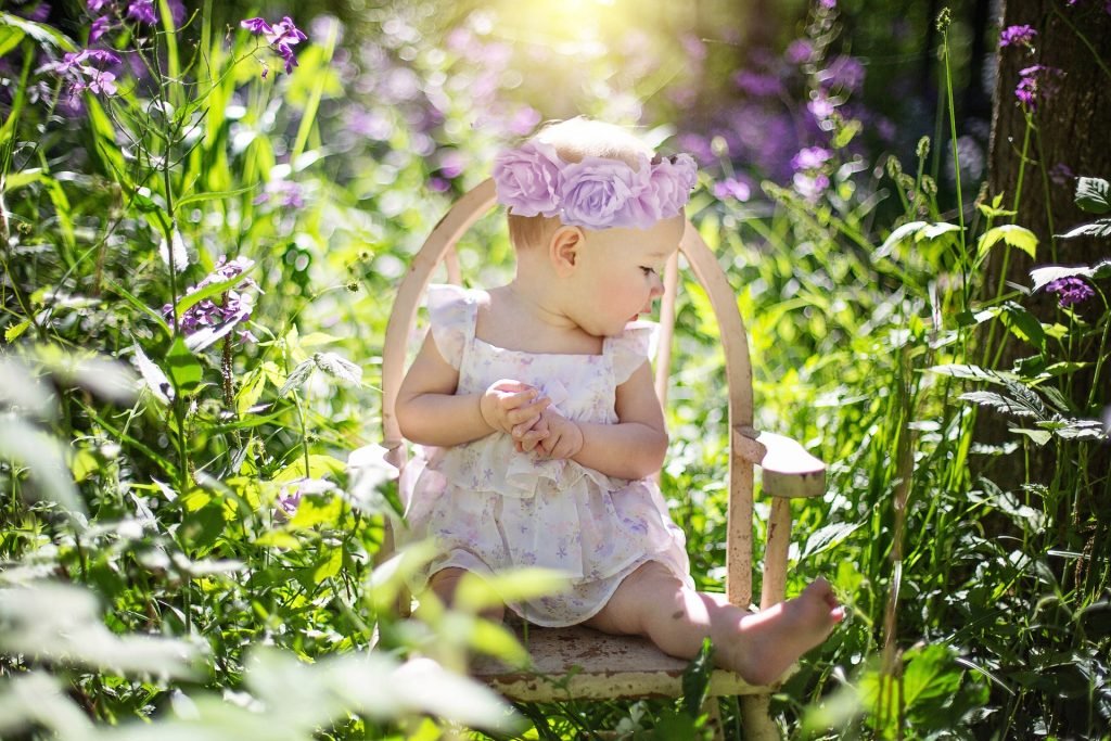 Baby girl sitting in wildflowers