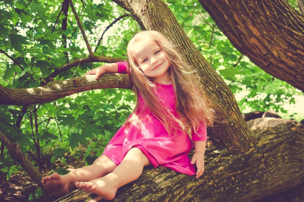 Baby Girl sitting on a tree