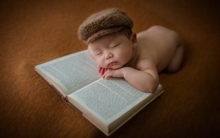 New born Boy Sleeping on a Book