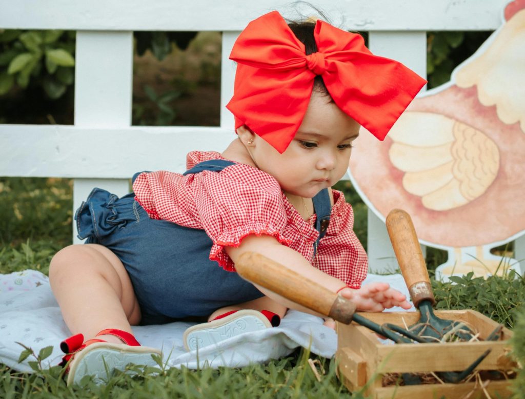 Cute Toddler sitting on a Blanket on a Grass