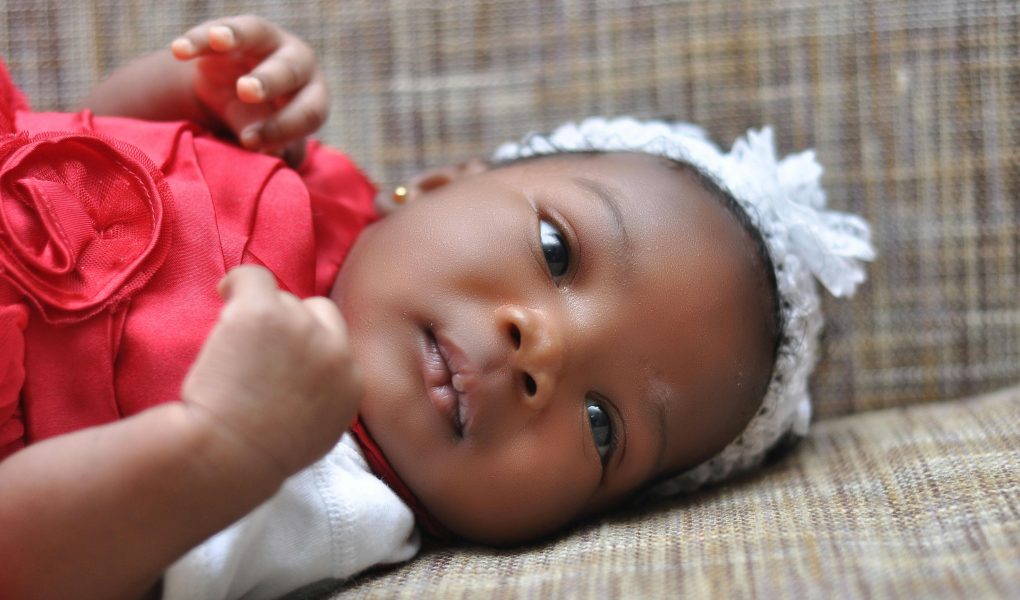 Baby Lying on Brown Cushion - Featured