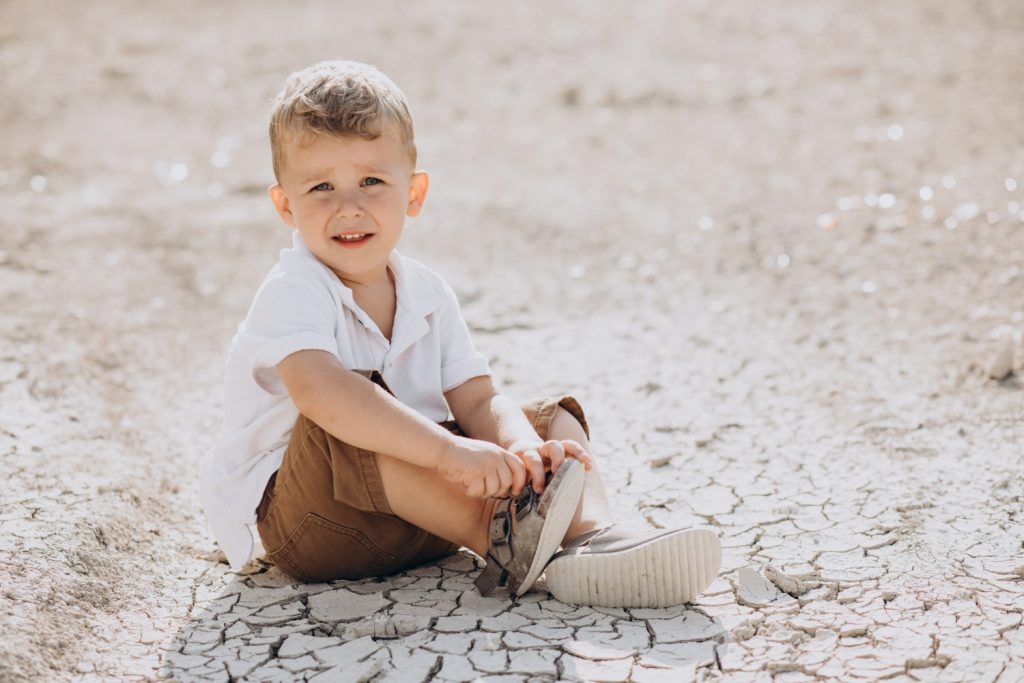 Young handsome boy sitting on the ground