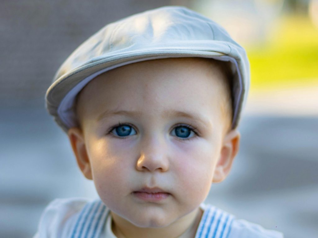 Toddler in a Cap and Overalls