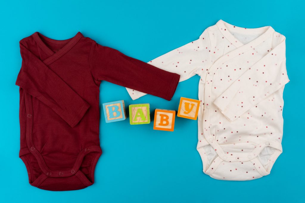 baby clothes on blue background top view