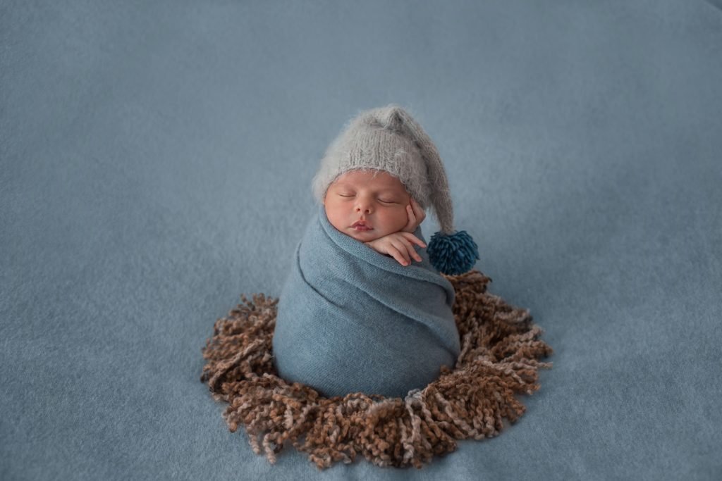 100 Modern Boy Names With Cool Nicknames 4 Newborn baby with white beret and wrapped with blue shawl