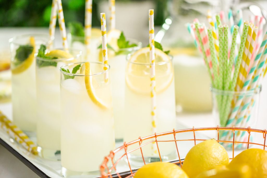 lemonade with a slice of fresh lemon and mint with paper straw