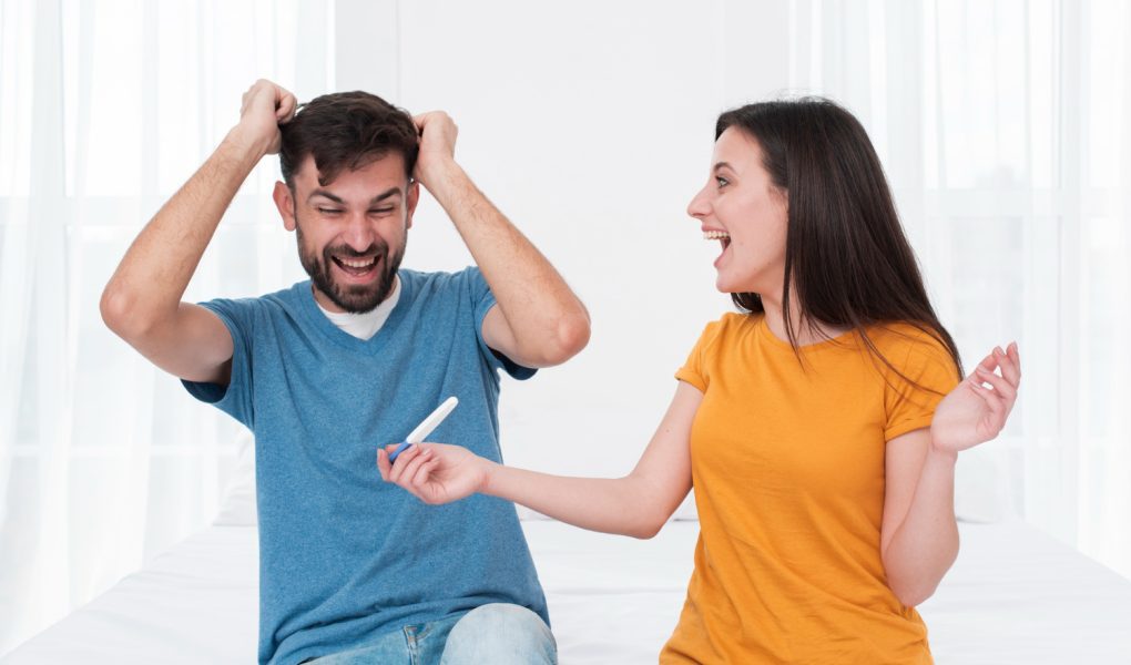 Excited couple holding pregnancy test