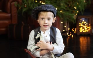 Little boy hugs figurine of rocking horse on christmas